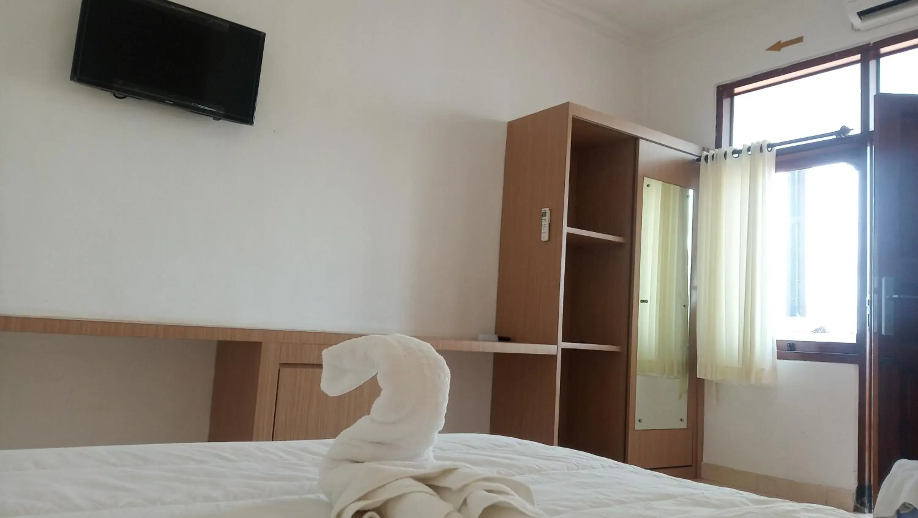 Bed, TV/Entertainment Center in Guest House Simalem