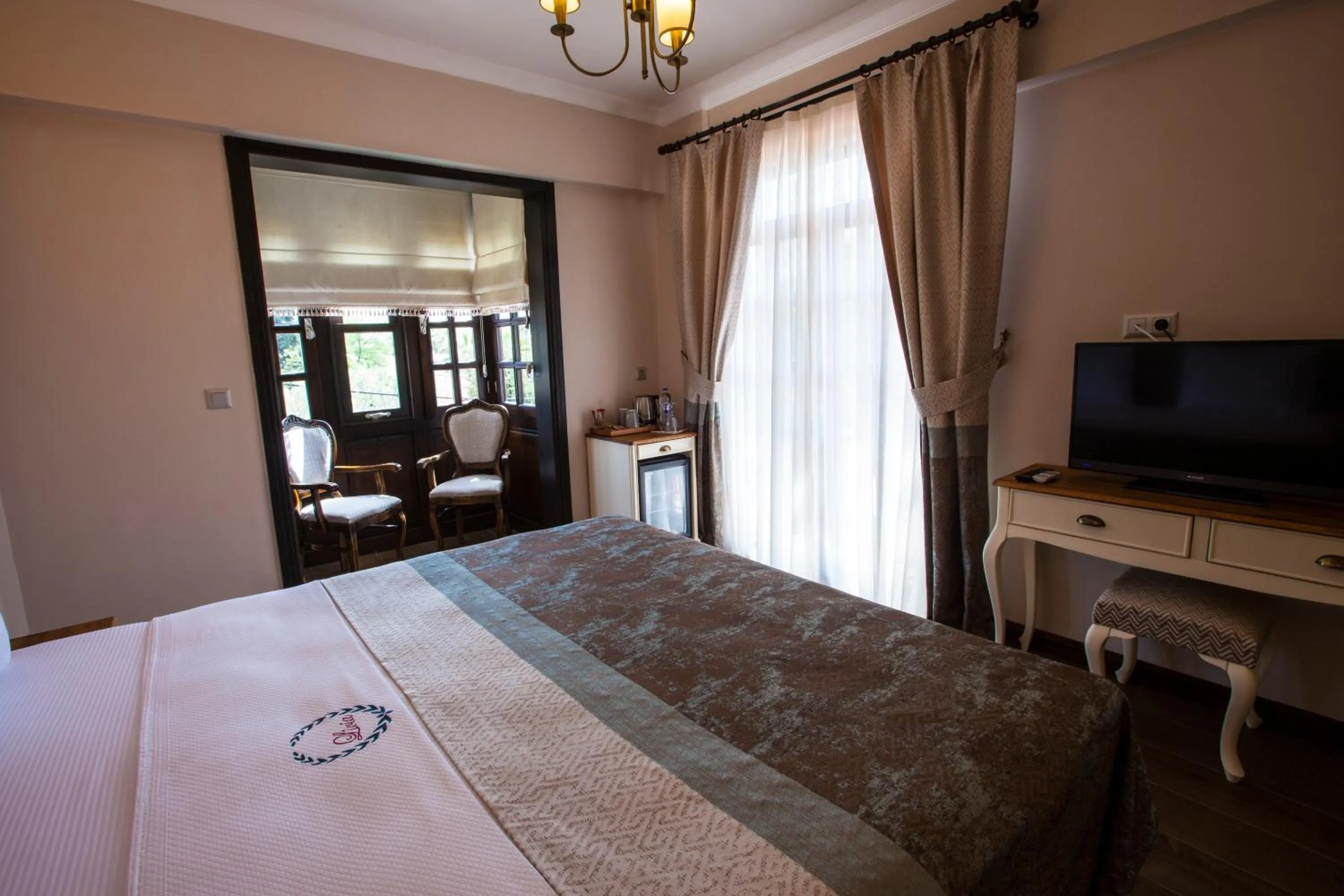 Communal lounge/ TV room, Bed in Livia Garden Hotel