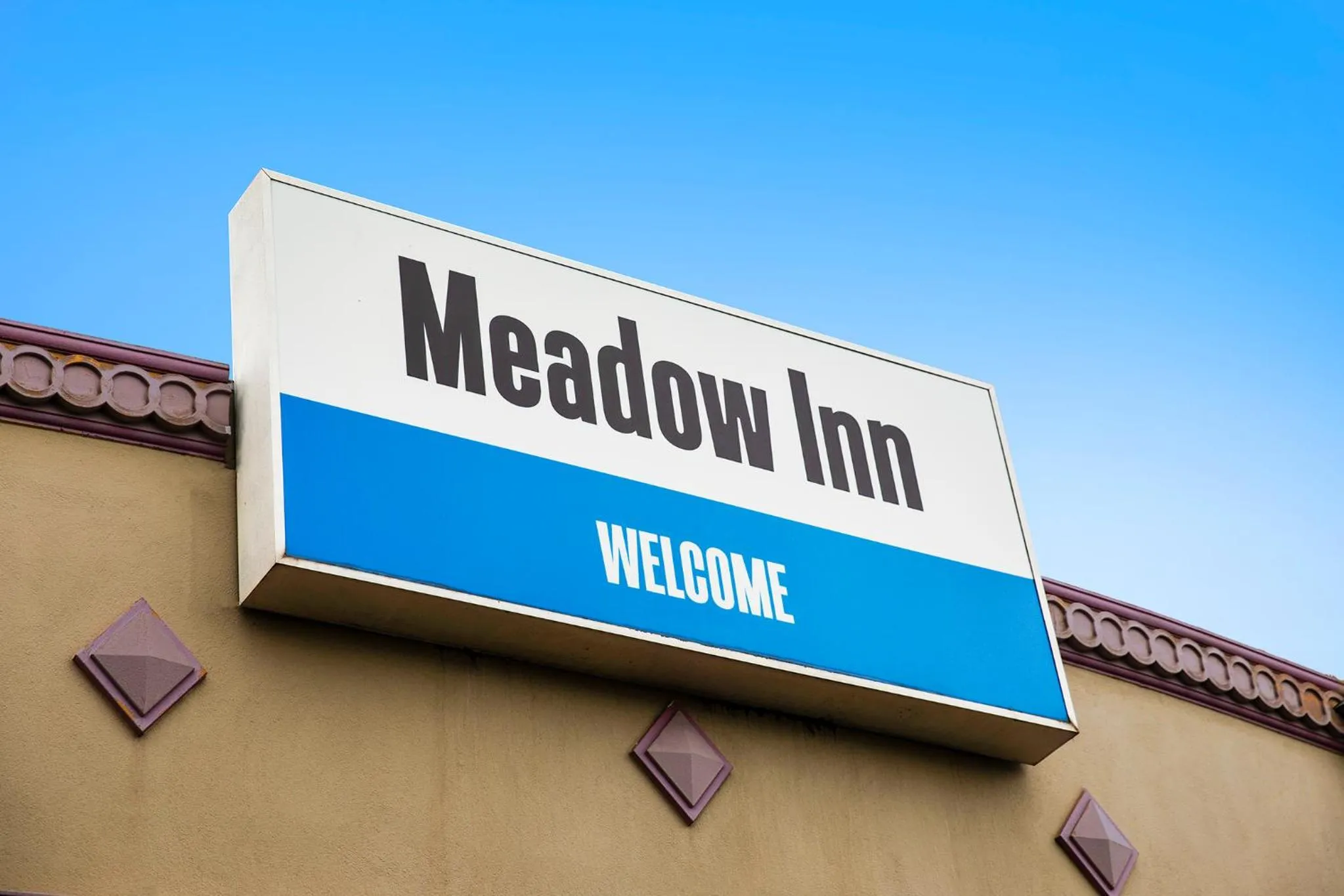 Property logo or sign in Meadow Inn Hotel-Motel
