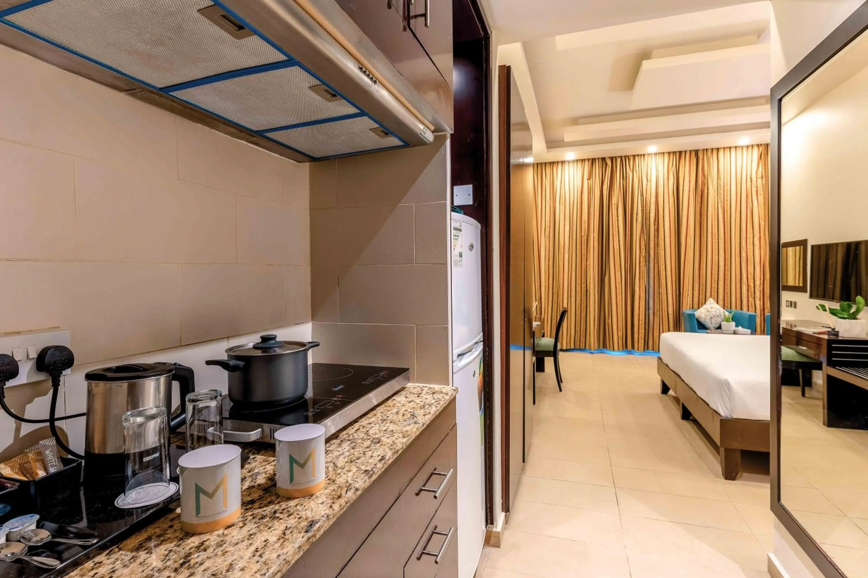 Kitchen or kitchenette, Bed in Metropolitan Al Mafraq Hotel