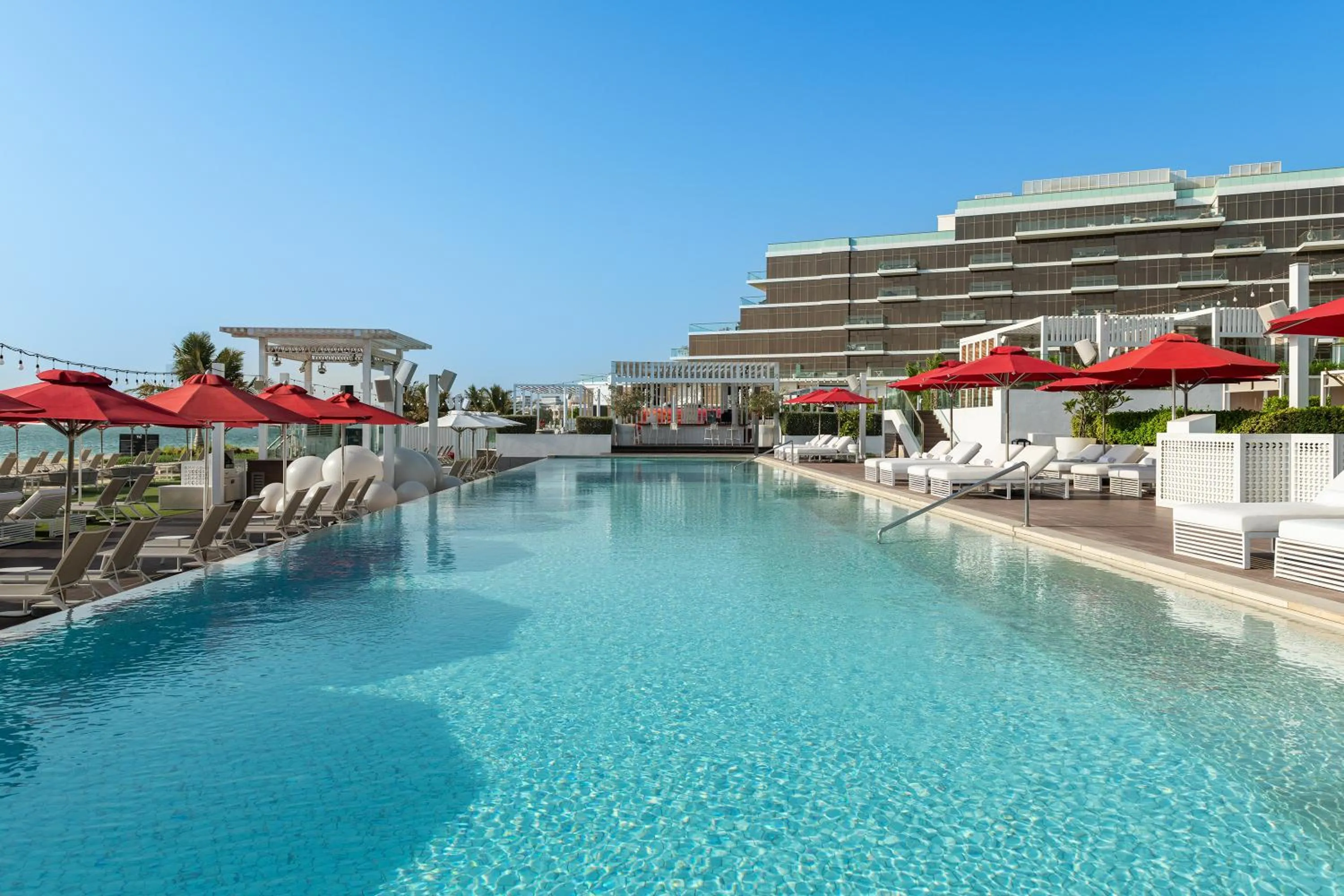 Swimming pool in Th8 Palm Dubai Beach Resort Vignette Collection, an IHG hotel