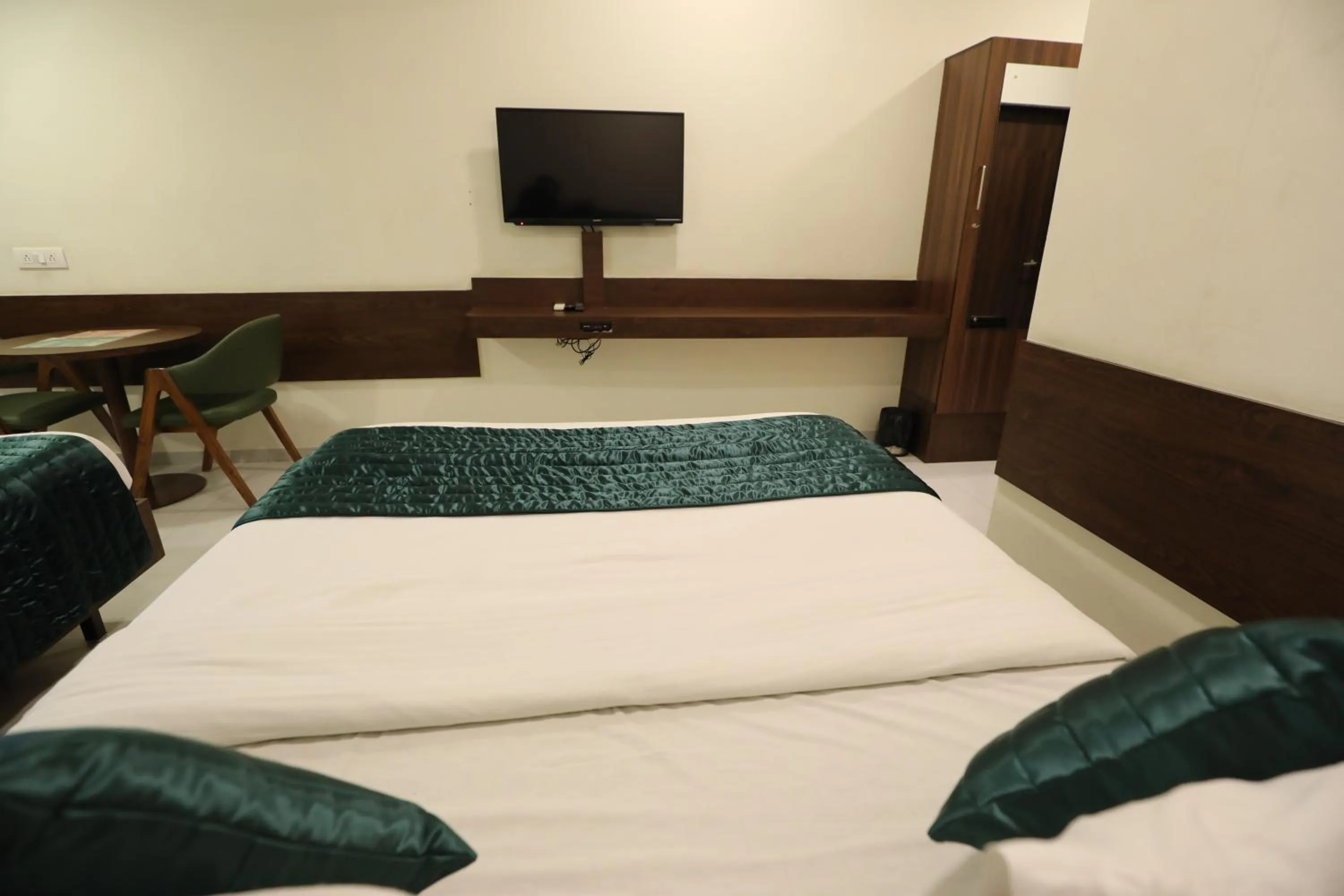 Communal lounge/ TV room, Bed in Greenotel Rooms Hazira, Surat