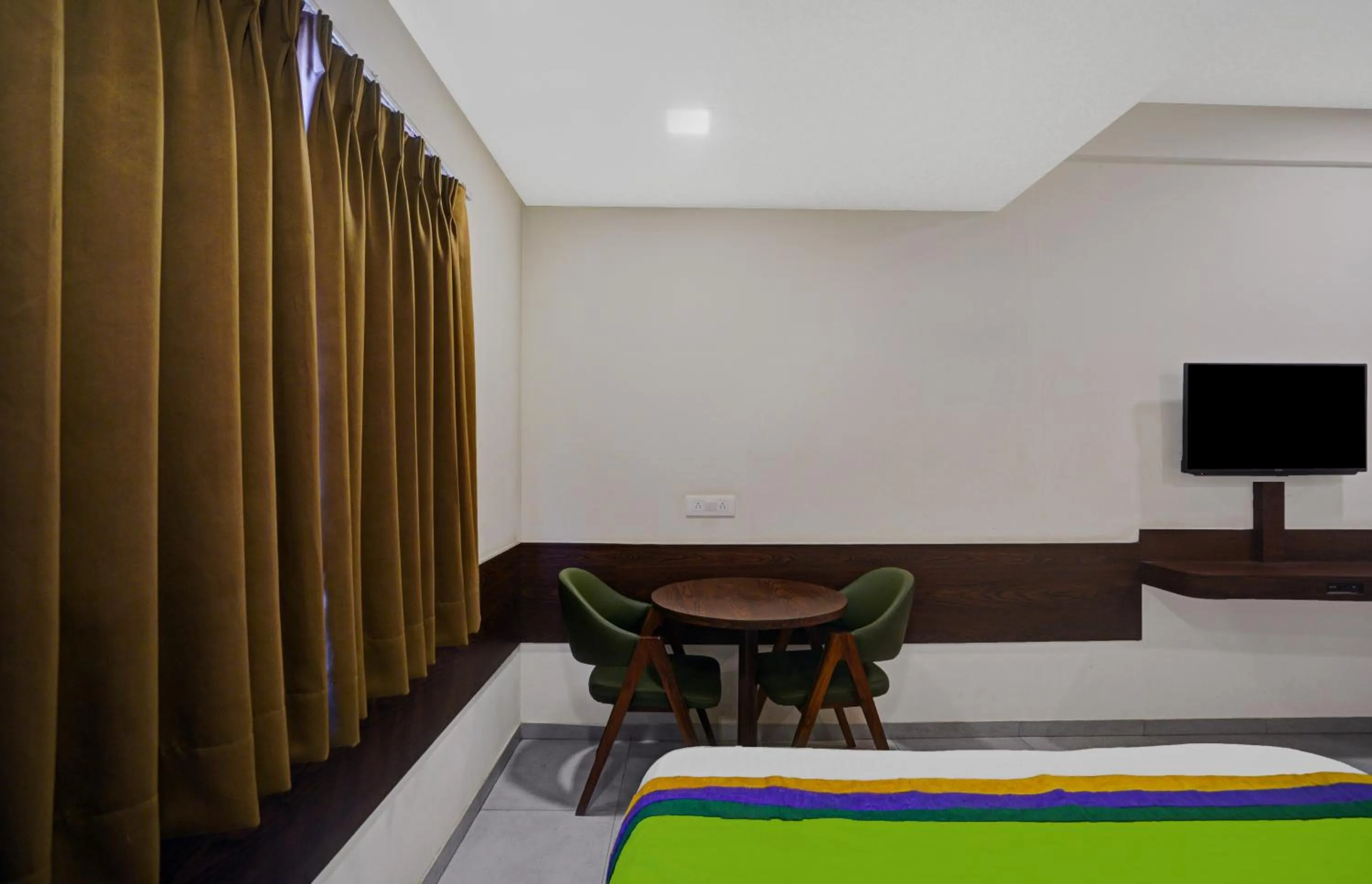 Communal lounge/ TV room, Bed in Greenotel Rooms Hazira, Surat