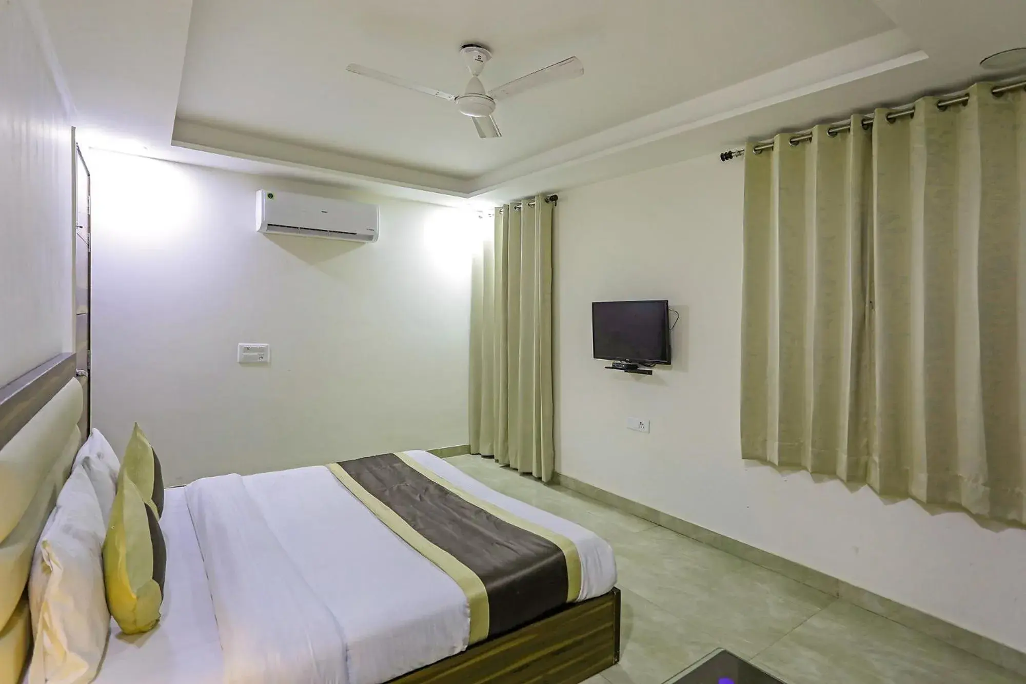 TV and multimedia, Bed in FabHotel White House BNB - Nr Yashobhoomi Convention Centre TV and multimedia, Bed in FabHotel White House BNB - Nr Yashobhoomi Convention Centre