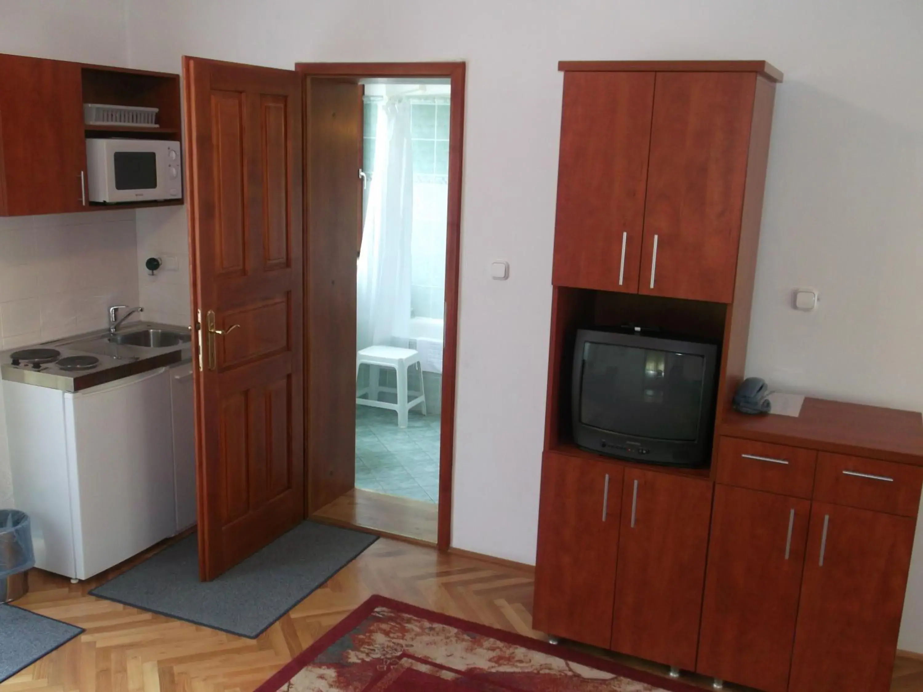 Kitchen or kitchenette, TV/Entertainment Center in HELIOS Hotel Apartments
