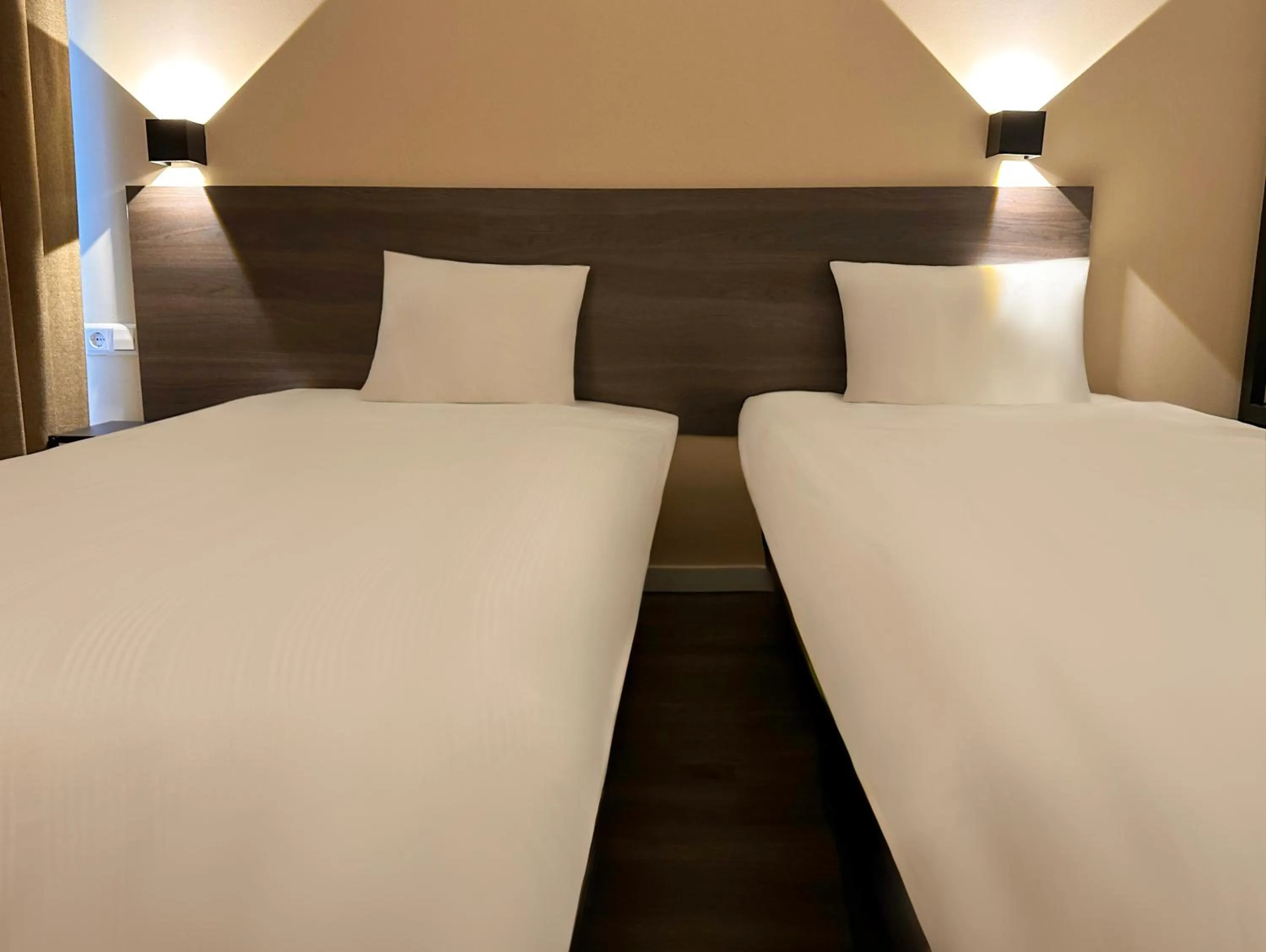 Bed in HOTELUX Amsterdam Airport Hotel