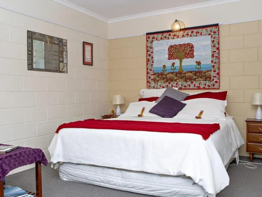 Bed in Moanarua Beach Cottage