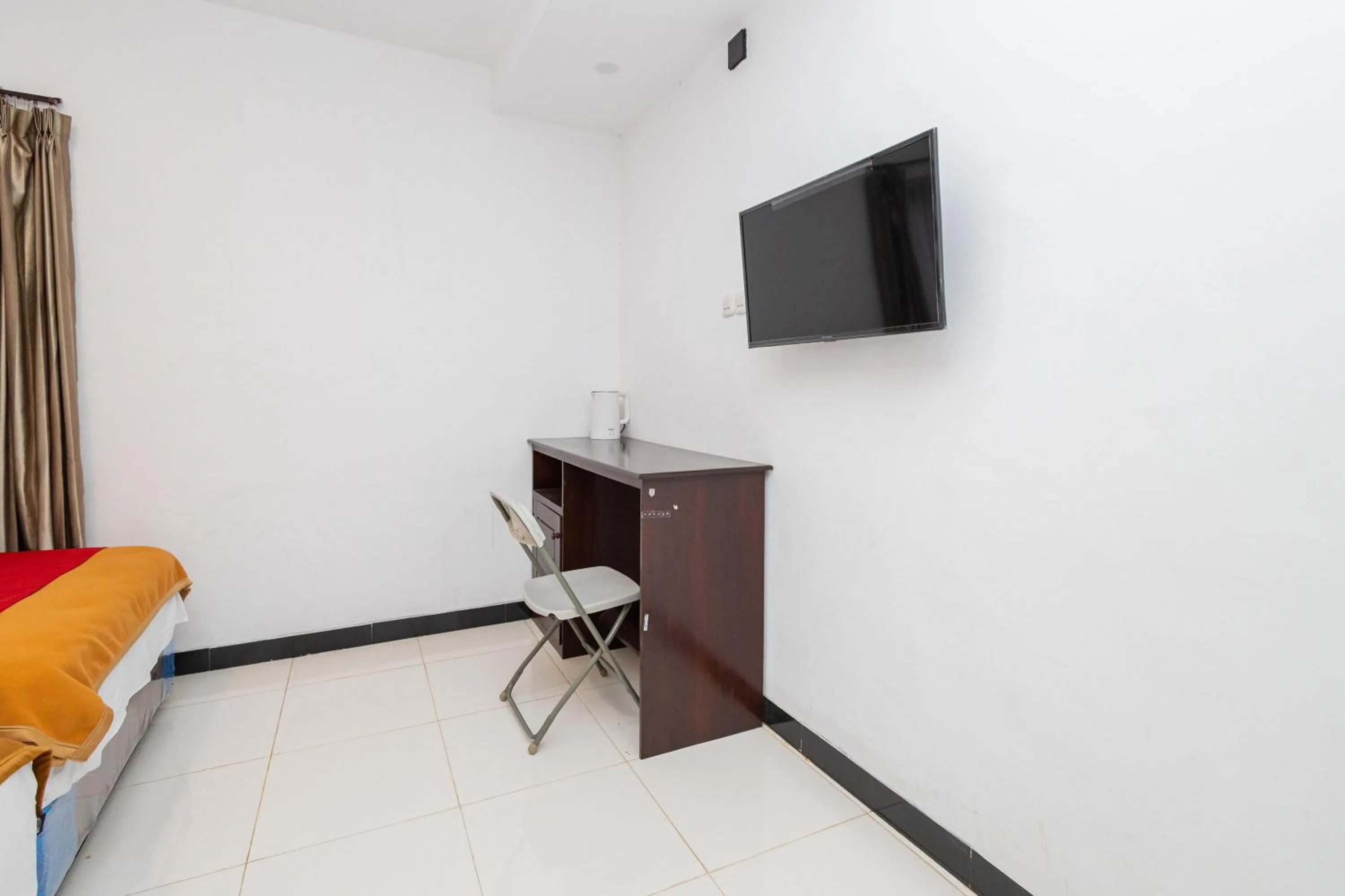 TV and multimedia in RedDoorz Syariah At Wisma Djokorio Poncokusumo