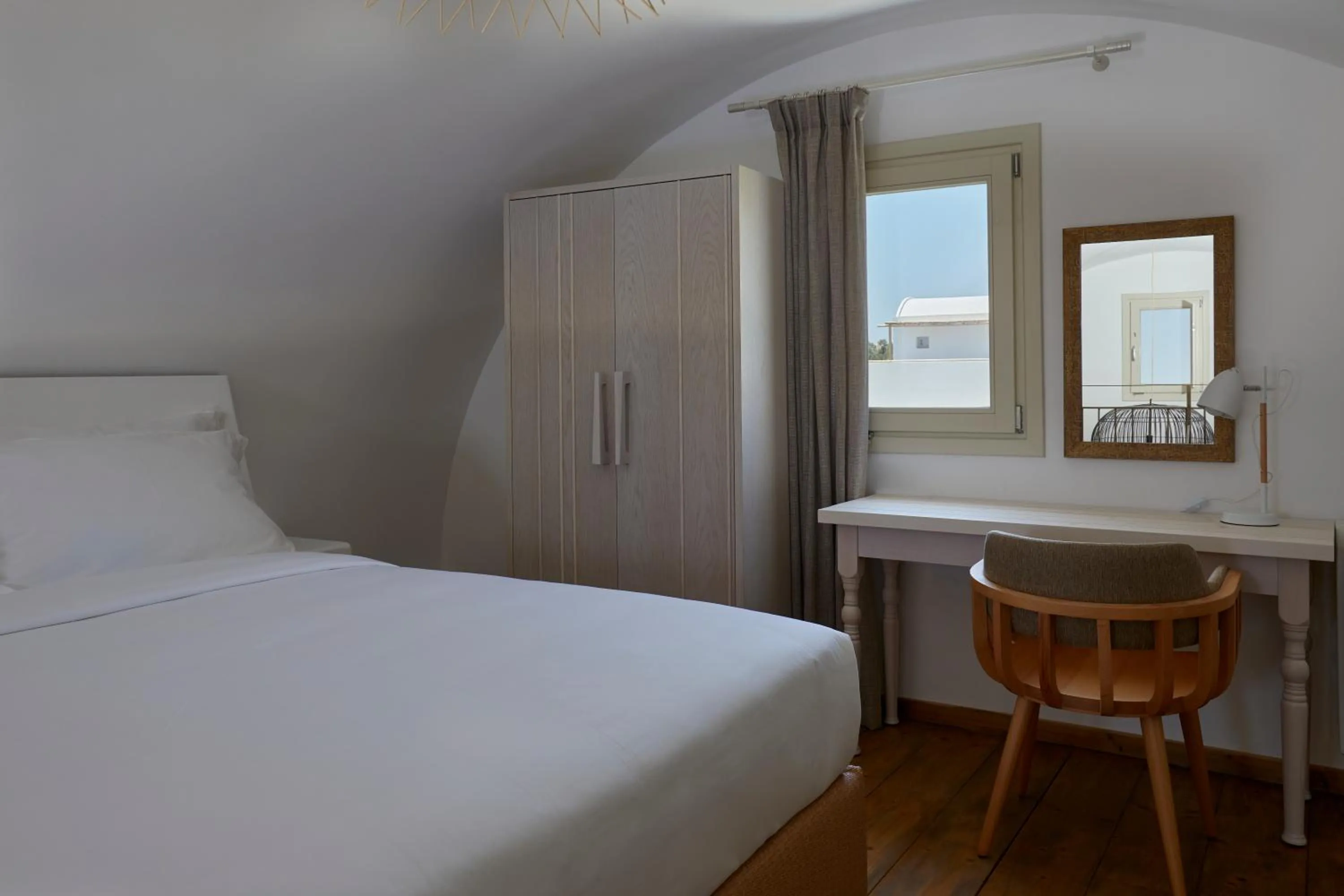 Bed in Sea Breeze Santorini Beach Resort, Curio By Hilton