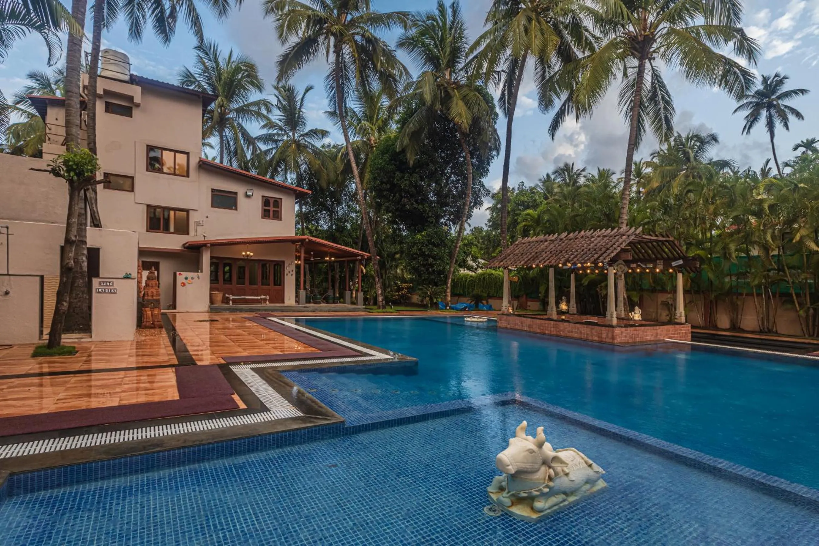 Property building in SaffronStays Casa Del Palms - 8BR luxury pool villa with gazebo, pickleball, bar & lawns near Nagaon Beach