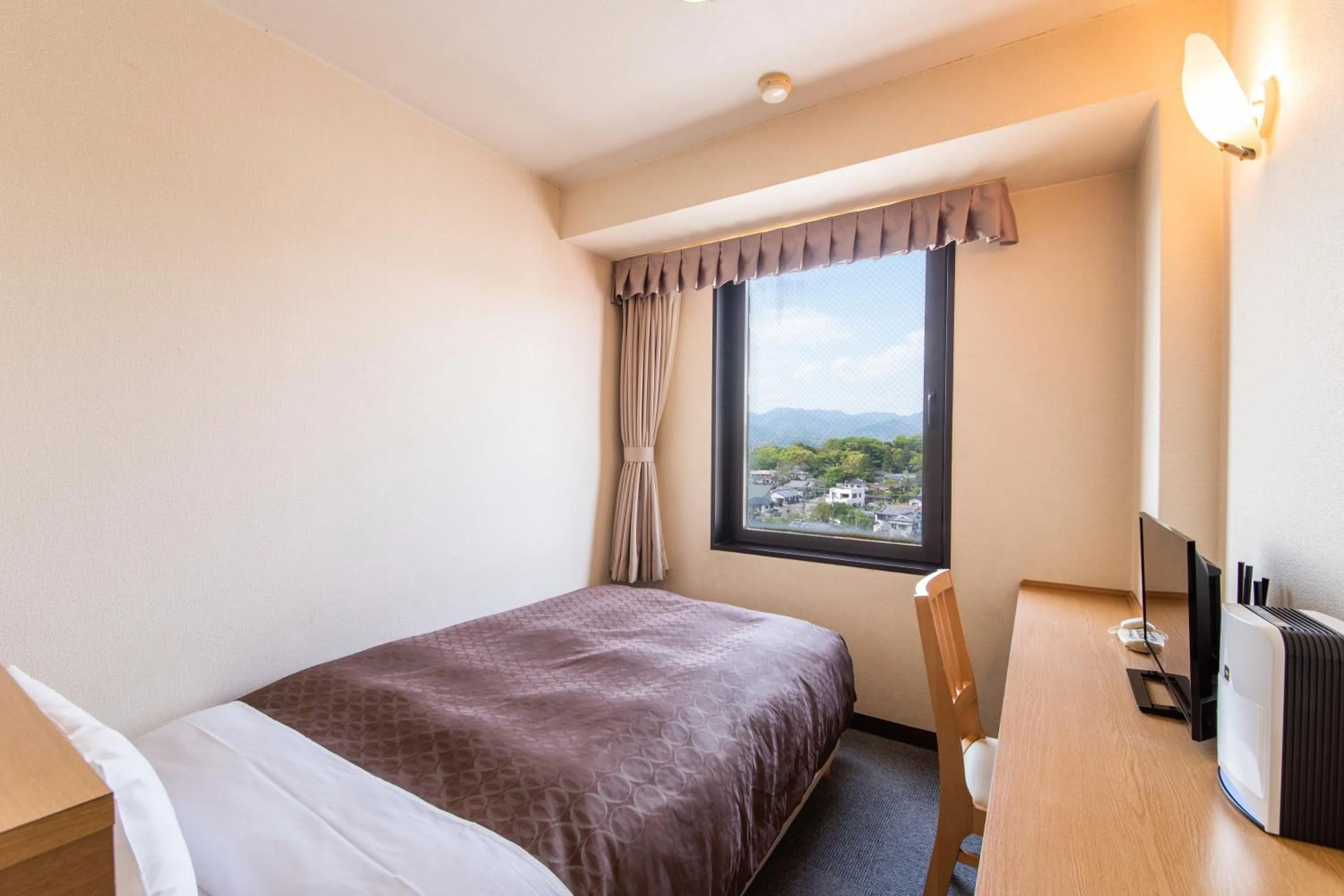 Bed in Hotel Primrose Saito