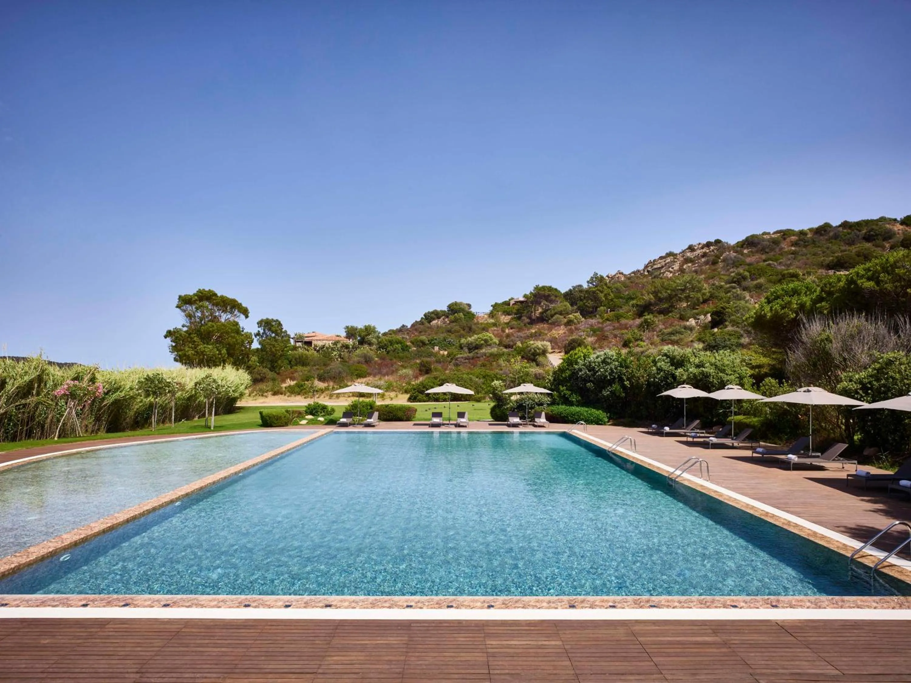 Pool view in Baia Di Chia Resort Sardinia, Curio Collection By Hilton