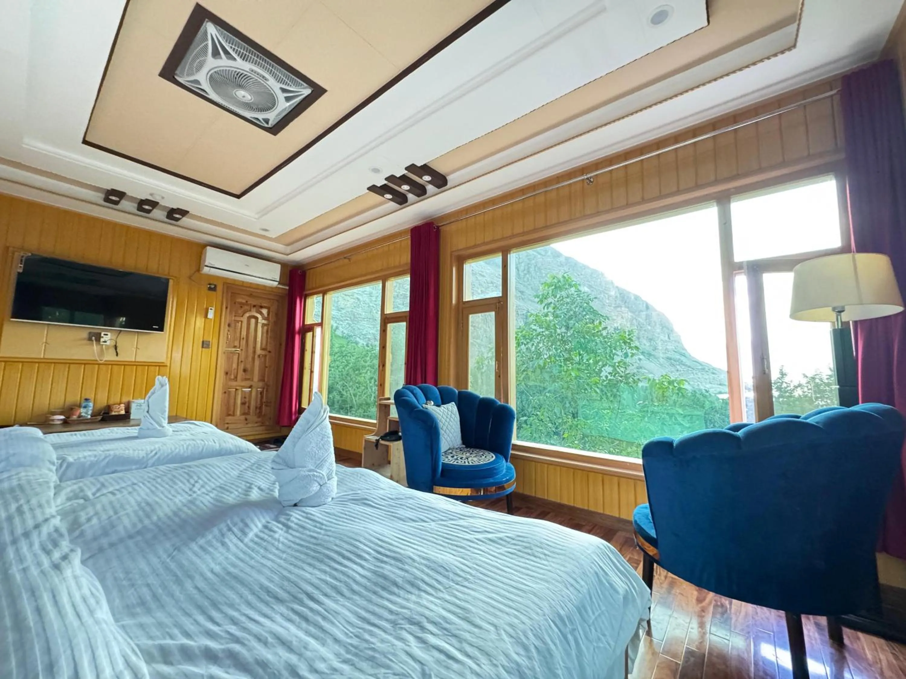 Communal lounge/ TV room, Bed in North Palace Khaplu