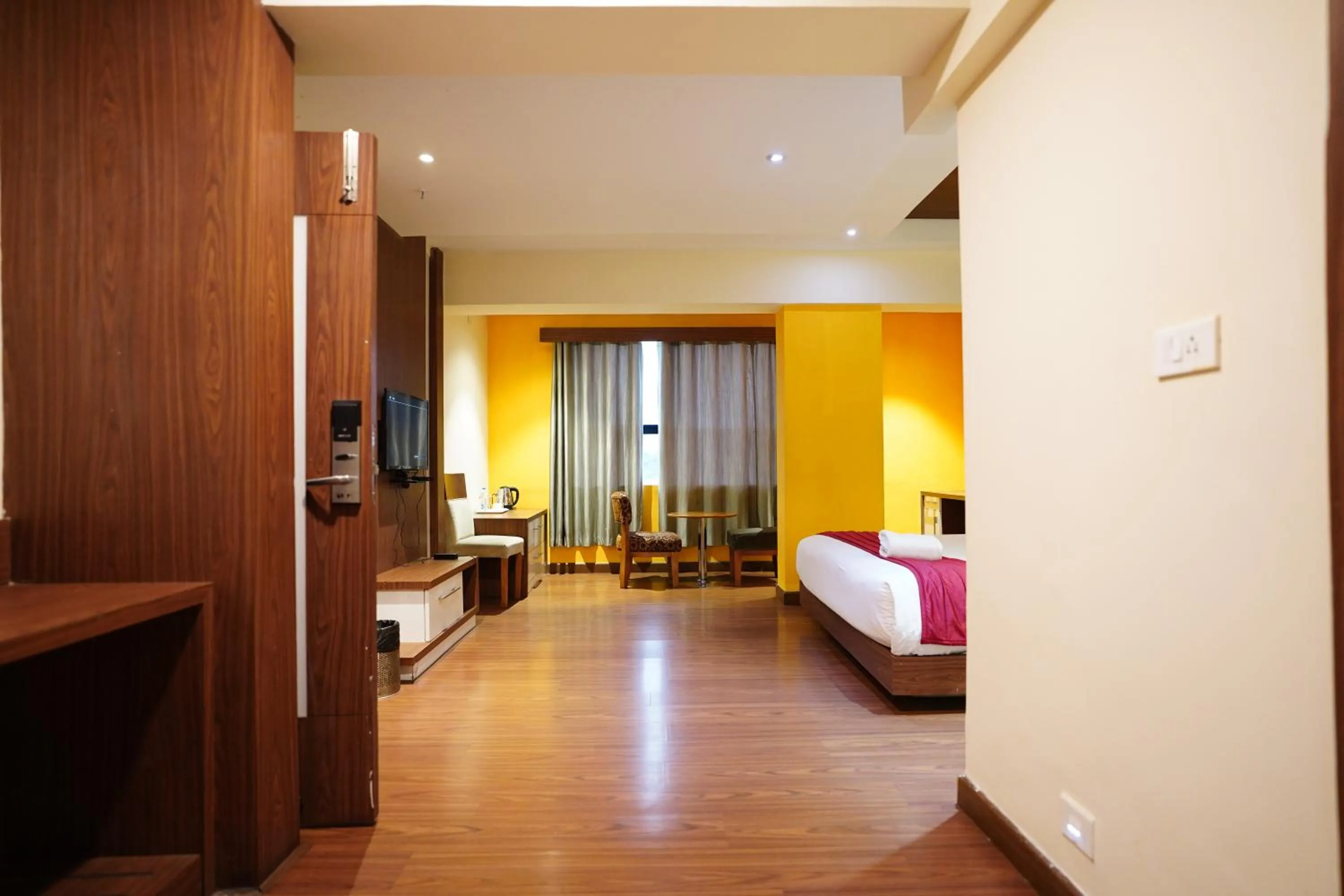 Communal lounge/ TV room, Bed in Emarald Hotel Calicut