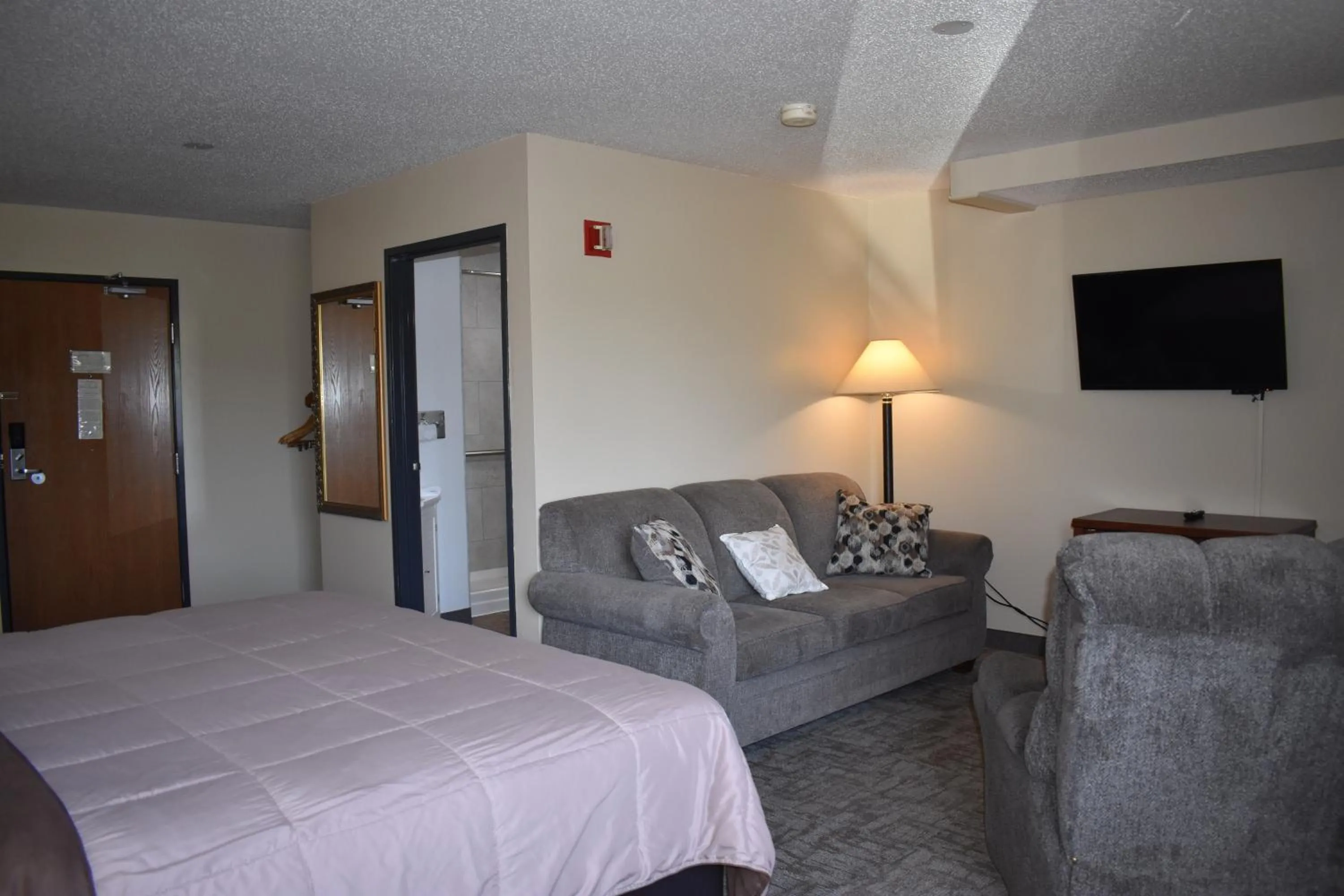 Seating area, Bed in Heartland Hotel & Suites