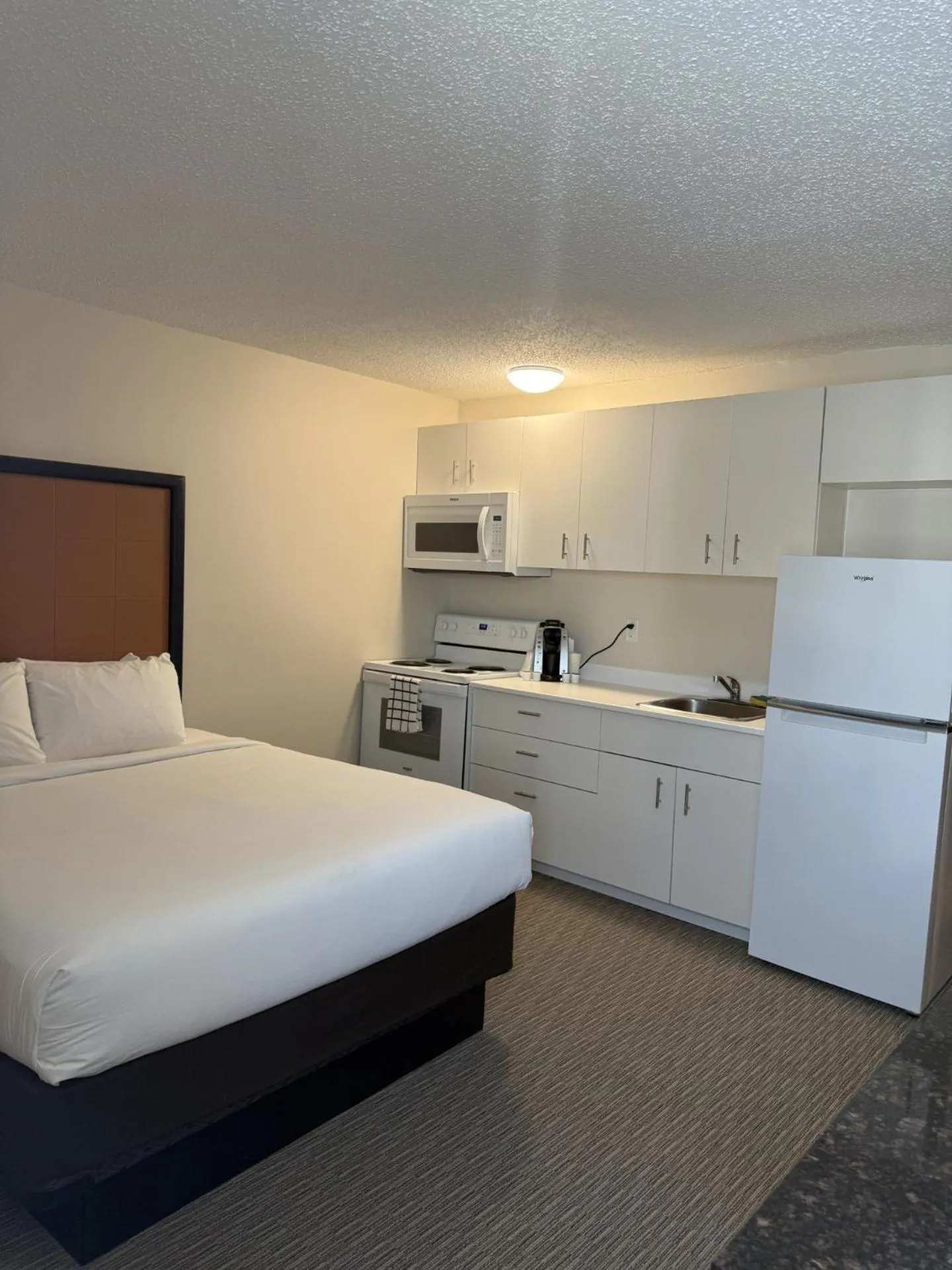 Kitchen or kitchenette, Bed in Anavada Inn & Suites - Grande Prairie