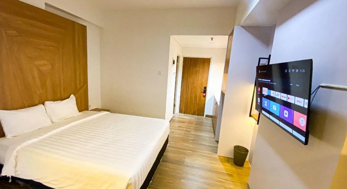 Communal lounge/ TV room, Bed in Menara One Hotel by Menara Santosa