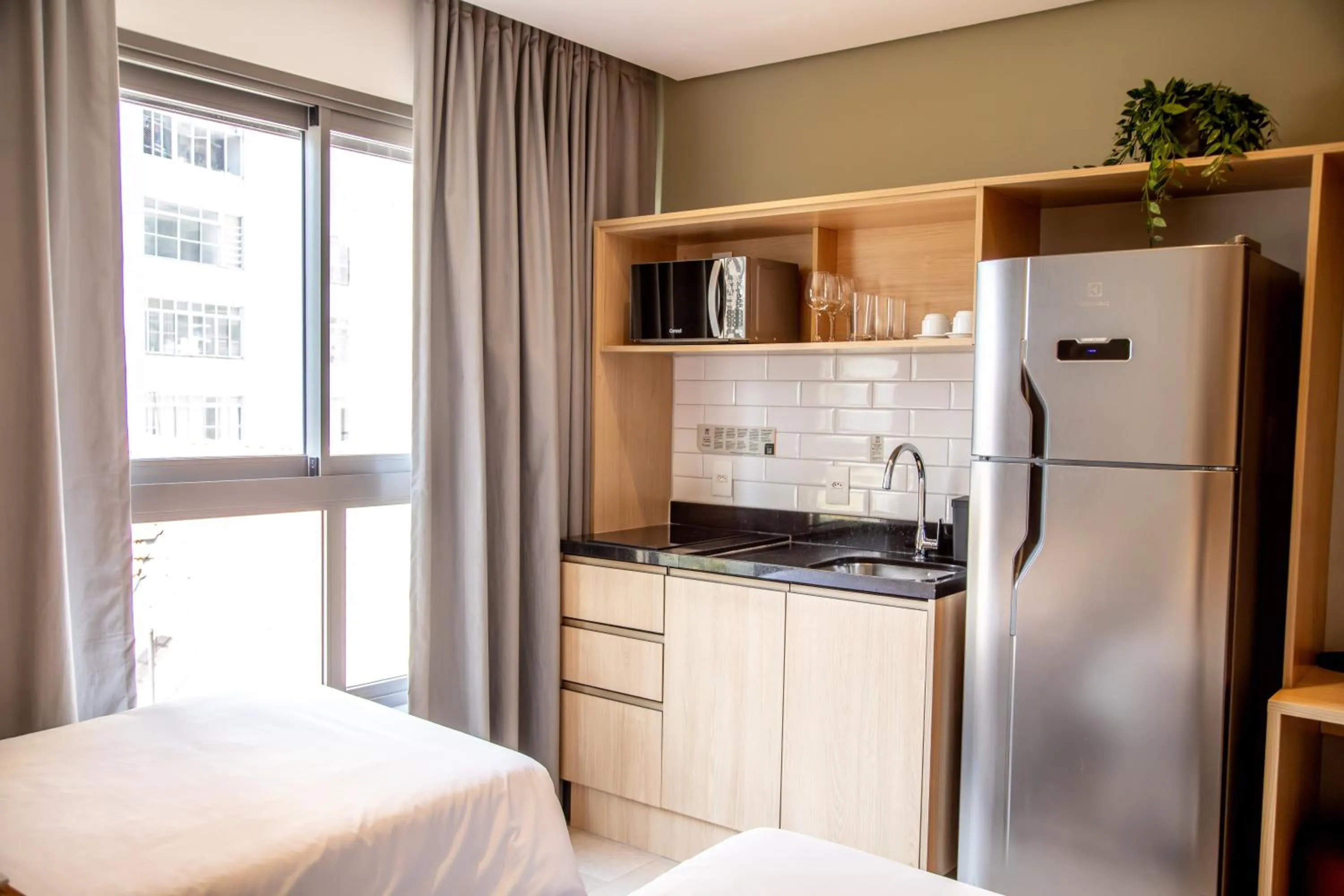 Kitchen or kitchenette, Bed in Cozzy Suites Paraíso Hotel