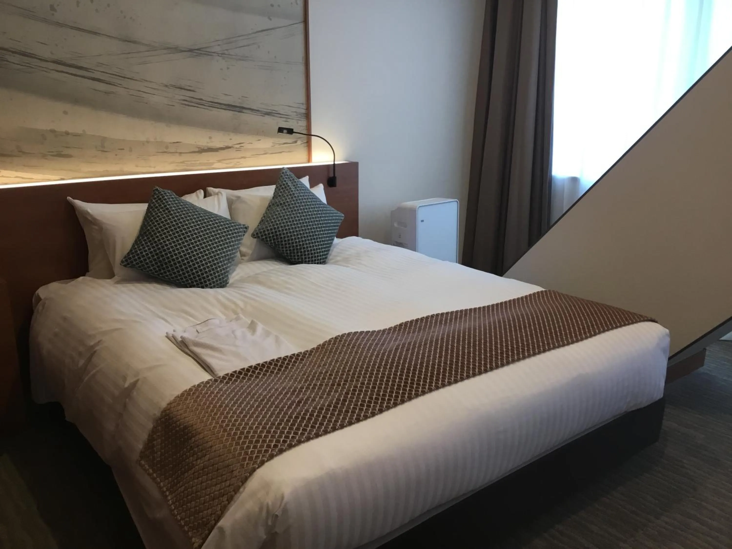 Bed in Odysis Suites Osaka Airport Hotel