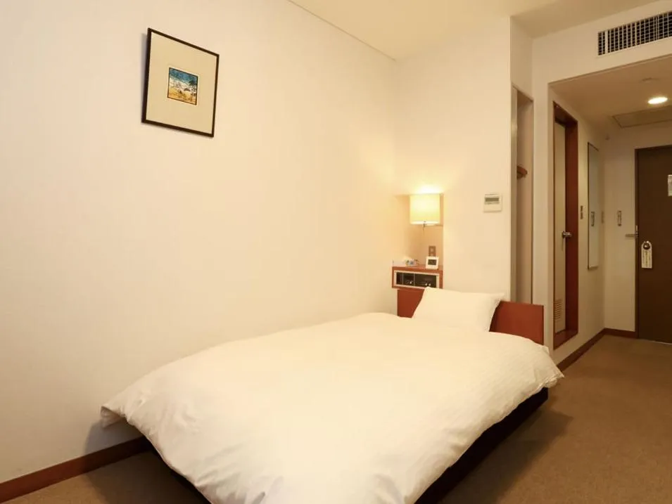 Bed in KANEMITSU CAPITAL HOTEL