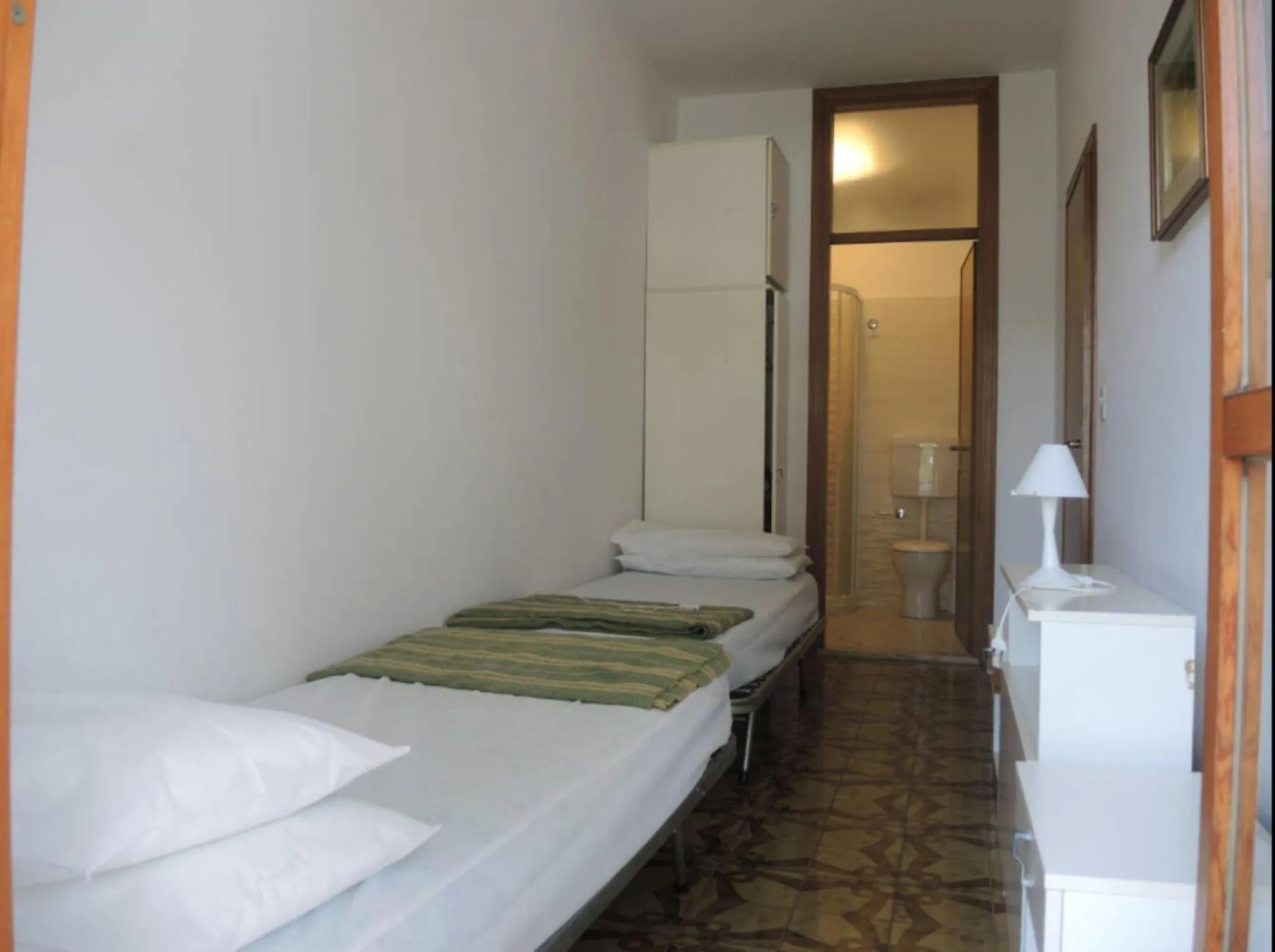Toilet, Bed in Family apartment steps from Pluto Beach