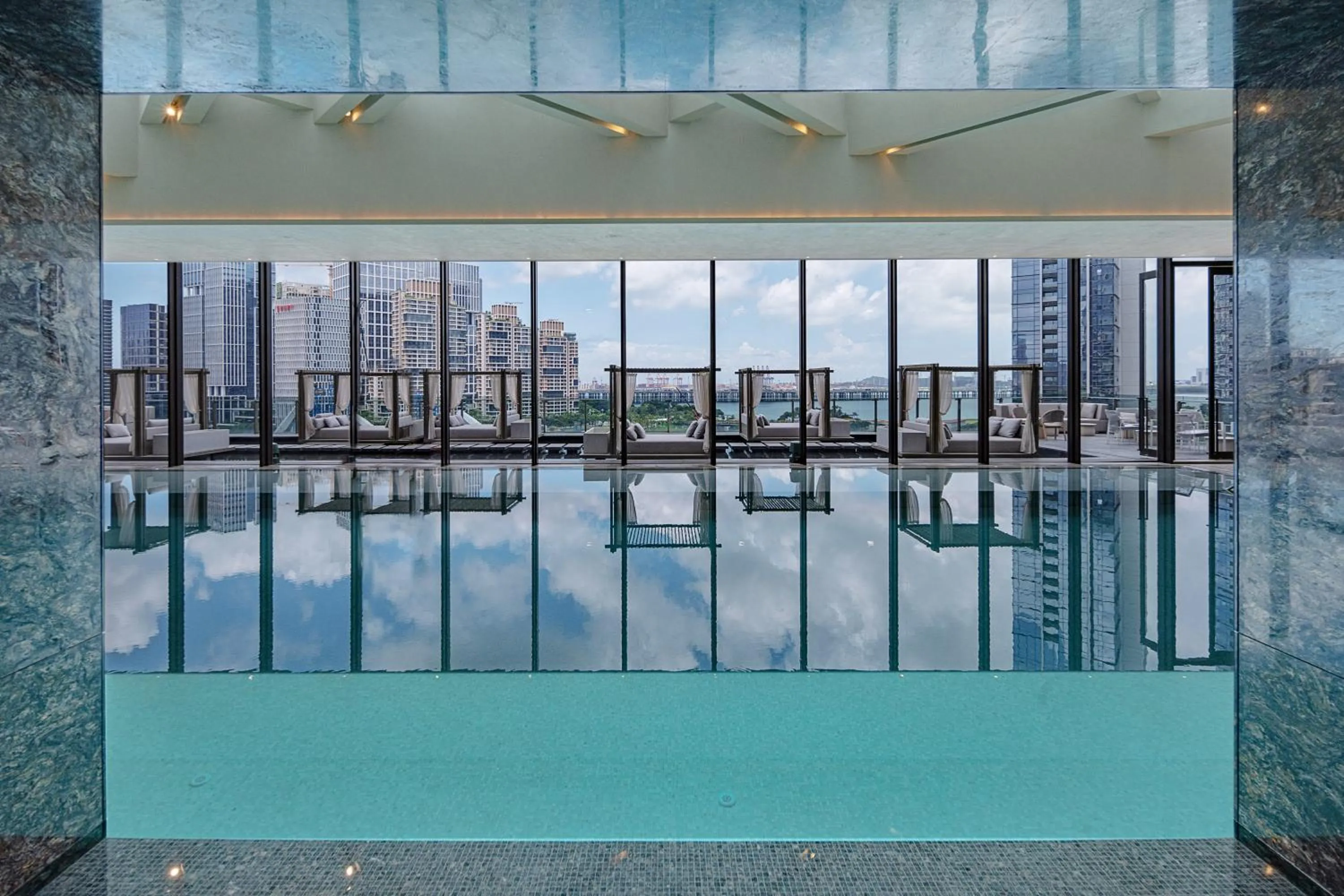 Swimming pool in Conrad Shenzhen, the first art museum hotel in Greater Bay Area with the stunning bay and sunset view in the hotel terrace